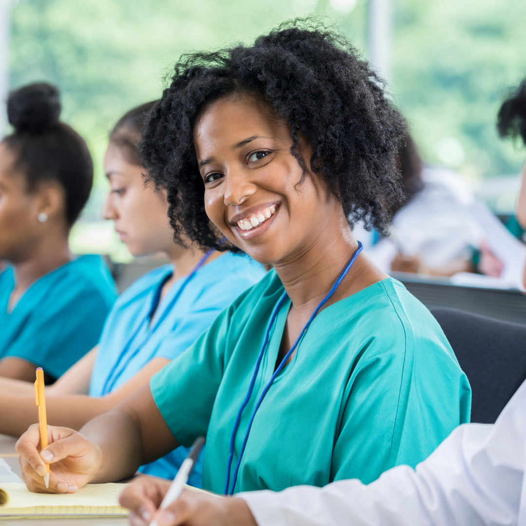 Smiling female medical professional in a classroom setting, attending a training session on botulinum toxin applications in medicine, aesthetics, and therapy